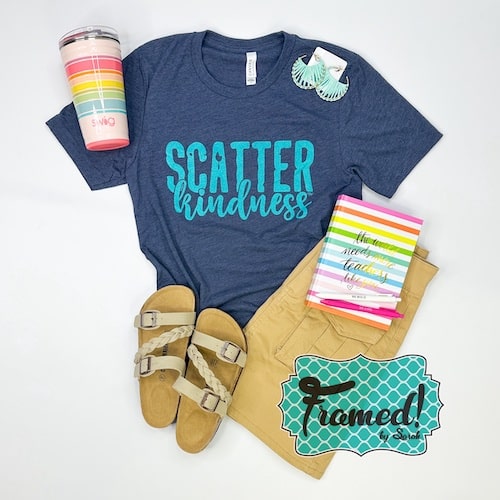Charcoal "scatter Kindness" graphic tee styled with Khaki Cargo Skirt, tan sandals, colorful striped tumbler, colorful triped notebook, teal earrings