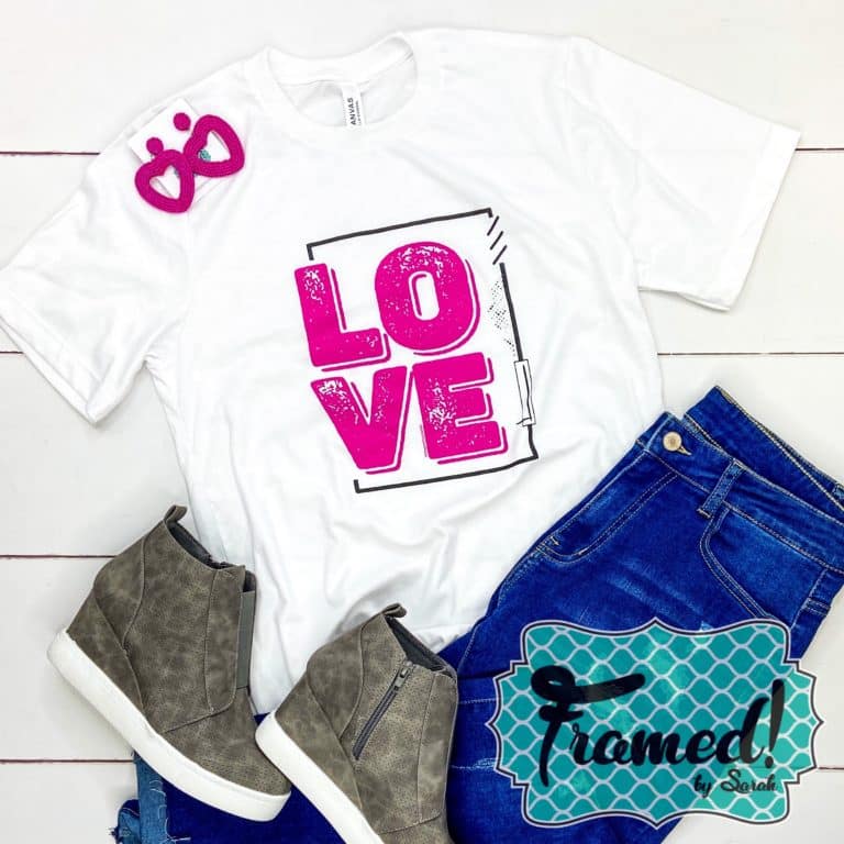 white "love" graphic tee styled with jeans and gray sneakers