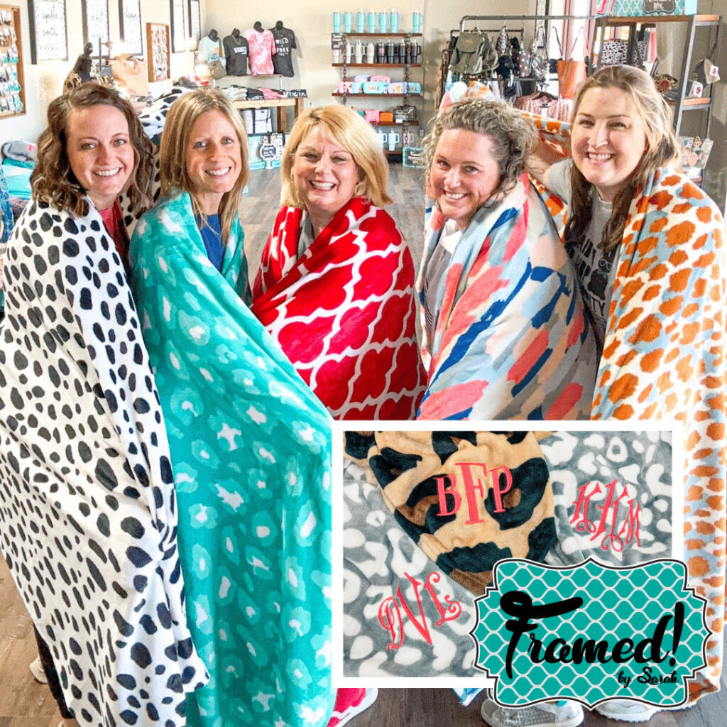 5 women posing in colorful monogrammed blankets