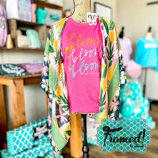 island printed floral kimono styled with a hot pink "bloom, bloom, bloom" shirt on a mannequin in a boutique