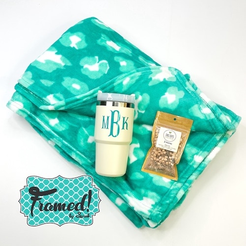 turquoise blanket with ivory monogrammed tumbler and snacks