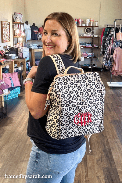 woman modeling leopard print backpack on back